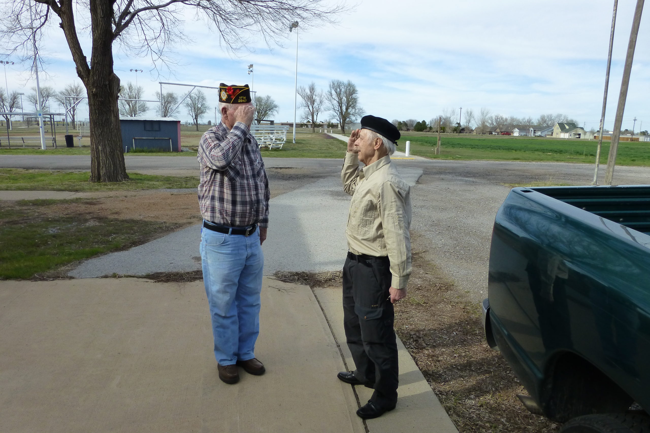 An American veteran and a German veteran salute each other