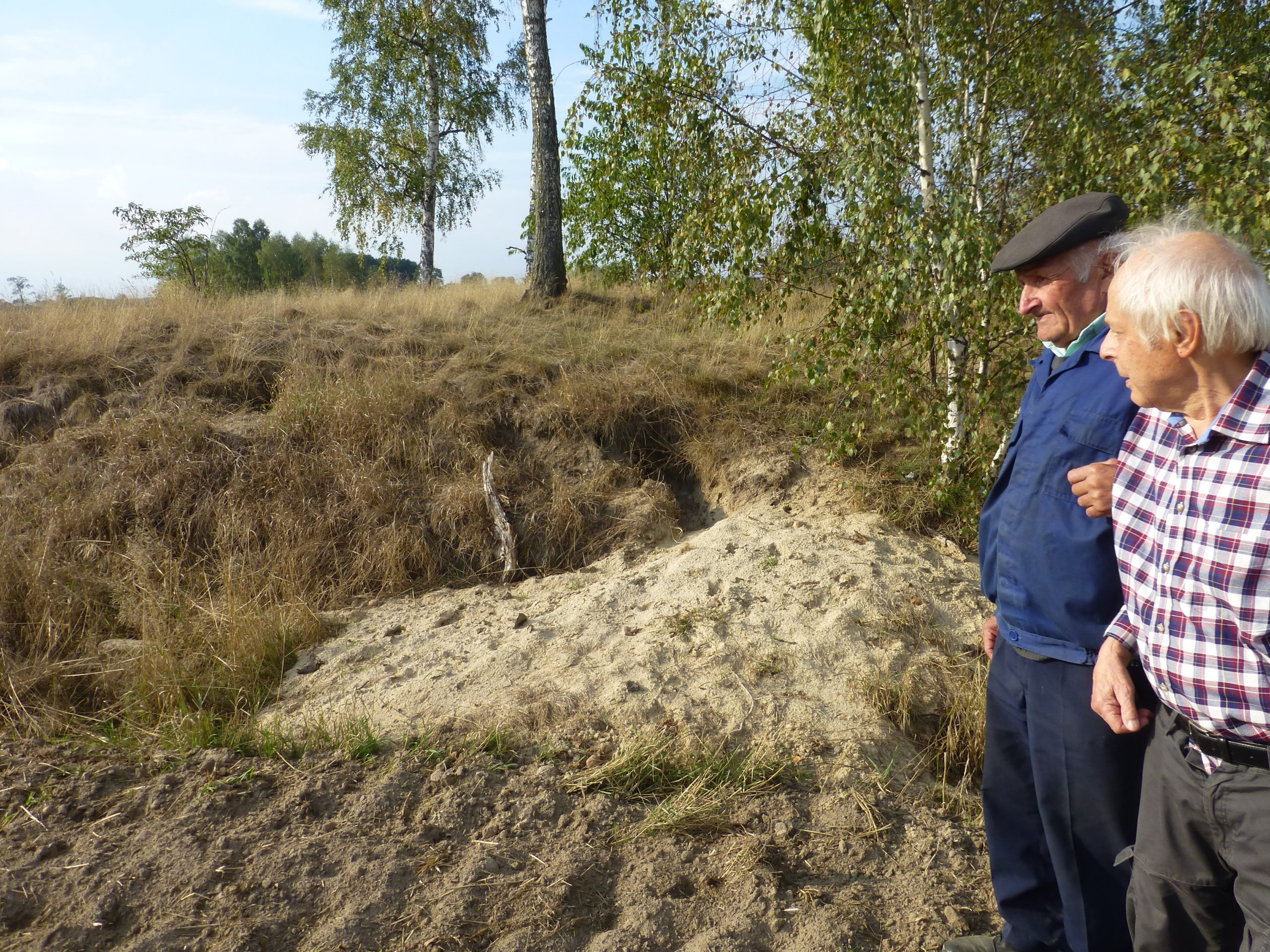 Local Polish villager Josef shows Charley Koenig where WWI German soldiers who died in a 1915 battle are buried in a field. Charley's father was horrifically wounded in the battle.