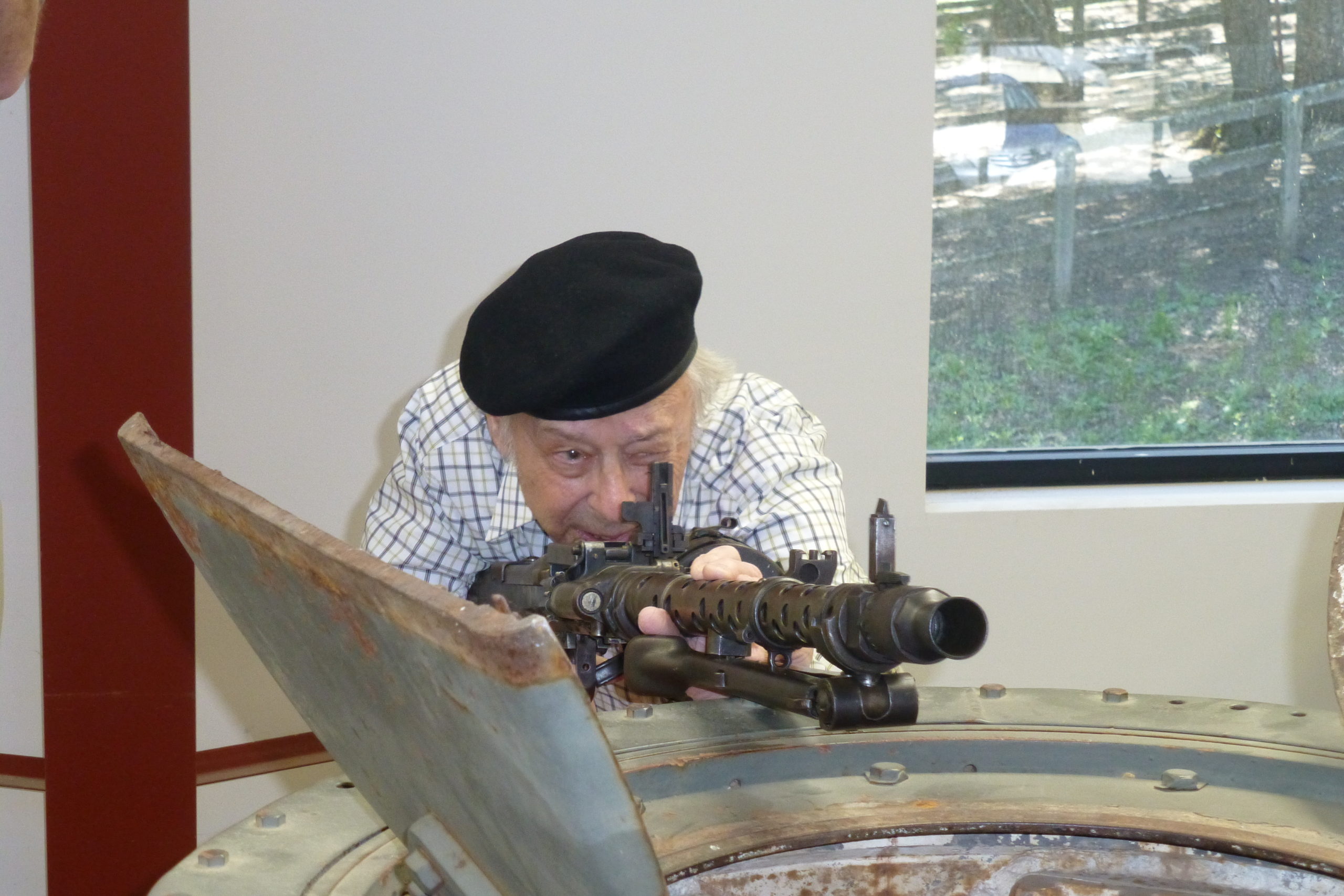 Charley Koenig aims an MG34 on top of the turret of a Panzer IV tank at the Jacques Littlefield private collection in 2013